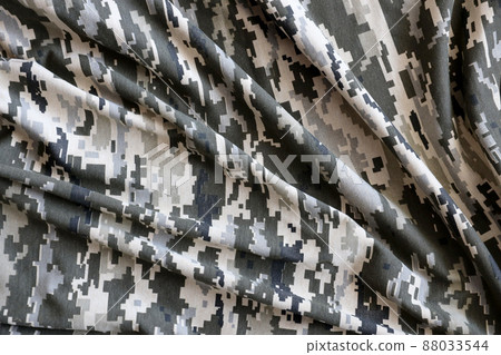 Fabric with texture of Ukrainian military pixeled camouflage. Cloth with camo pattern in grey, brown and green pixel shapes. Official uniform of Ukrainian soldiers 88033544