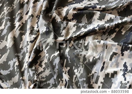 Fabric with texture of Ukrainian military pixeled camouflage. Cloth with camo pattern in grey, brown and green pixel shapes. Official uniform of Ukrainian soldiers Fabric with texture of Ukrainian military pixeled camouflage. Cloth with camo pattern in grey, brown and green pixel shapes. Official uniform of Ukrainian soldiers 88033598