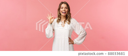 Portrait of carefree good-looking blond girl, wear white dress, guarantee you will like this special spring offer, show okay sign, agree or accept, smiling and nod in approval, pink background Portrait of carefree good-looking blond girl, wear white dress, guarantee you will like this special spring offer, show okay sign, agree or accept, smiling and nod in approval, pink background 88033681