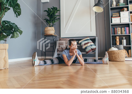 Young fit woman doing the splits working out at home Young fit woman doing the splits working out at home 88034368