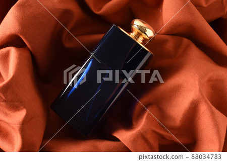 Perfume bottle wrapped in orange cloth 88034783