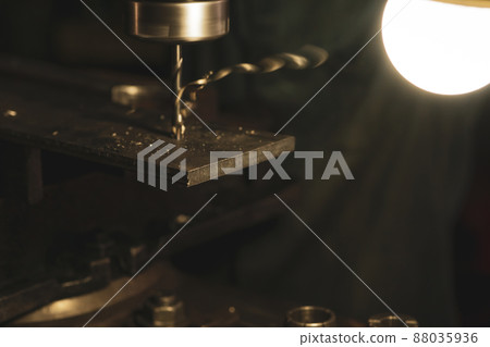 Selective focus metal plate milling with milling machine in factory. Tool for milling and drilling metal workpiece with light bulb. Steel manufacturing factory. Milling process. Machine in workshop. 88035936