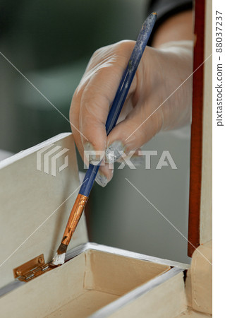 Women's gloved hands work with an artistic brush, repainting furniture Women's gloved hands work with an artistic brush, repainting furniture 88037237