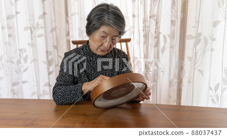 An elderly woman in black clothes repairing a broken and stuck watch An elderly woman in black clothes repairing a broken and stuck watch 88037437