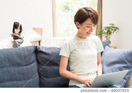 和在客廳工作的媽媽一起學習的女孩 和在客廳工作的媽媽一起學習的女孩 88037933