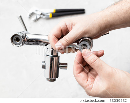 hands install paronite gasket in faucet and wrench 88039382