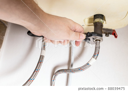 hand installs valve by adjustable wrench on boiler 88039475