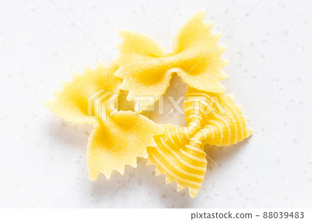 few uncooked farfalle pasta pieces on gray 88039483