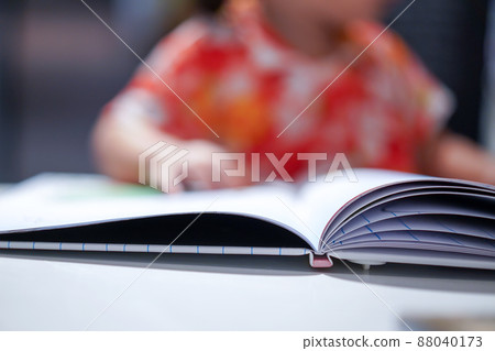 Asian girl kid concentrated read a book, close up at the book. 88040173