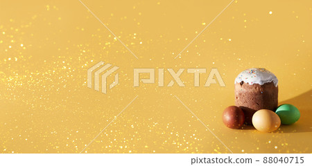 A banner with colored Easter eggs and a cake on a yellow background with a golden sheen. With a place to copy. Orthodox Easter. High quality photo 88040715