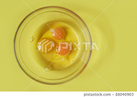 Three raw eggs on a yellow background with a space to copy. Healthy food. Fashionable color. High quality photo 88040903