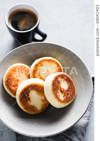 Cottage cheese fritters in craft ceramic bowl 88041403