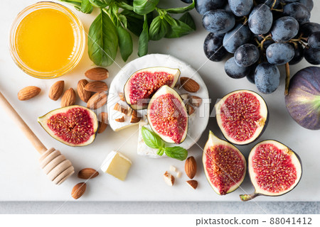 Cheese platter with brie or camembert, figs, grapes, nuts and honey Cheese platter with brie or camembert, figs, grapes, nuts and honey 88041412