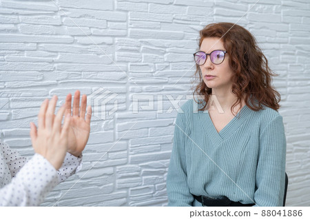 The psychotherapist conducts a hypnosis session. Female patient under hypnosis. The psychotherapist conducts a hypnosis session. Female patient under hypnosis. 88041886