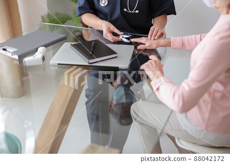 Female pediatrician examining old woman at home Female pediatrician examining old woman at home 88042172