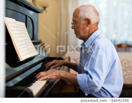 Senior man learning to play piano 88042398