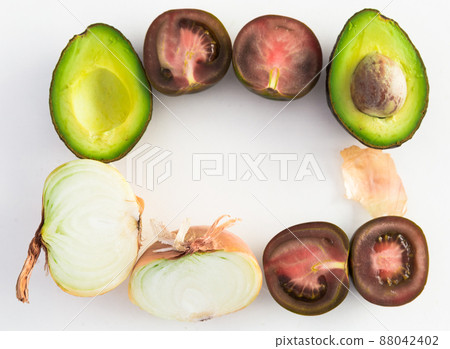 frame of vegetables black tomatoes, avocado and onions on white background frame of vegetables black tomatoes, avocado and onions on white background 88042402