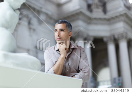 Adult man is visiting museum and looking at the exposition Adult man is visiting museum and looking at the exposition 88044349