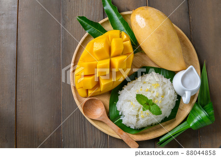 Top view of Coconut Flavored Sticky Rice with Ripe Mango on wood dish, .Popular Thai desserts Top view of Coconut Flavored Sticky Rice with Ripe Mango on wood dish, .Popular Thai desserts 88044858