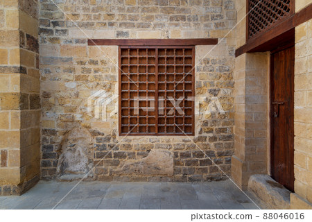 Mamluk era wooden closed window with wooden ornate grid over stone bricks wall Mamluk era wooden closed window with wooden ornate grid over stone bricks wall 88046016