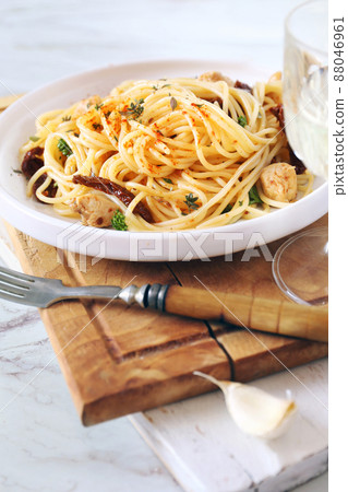 Italian cuisine. Spaghetti with dried tomatoes, garlic grilled chicken and glass of white wine 88046961