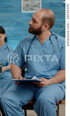 Patient with disability doing consultation with man nurse in nursing home. Medical assistant talking to senior person sitting in wheelchair, for healthcare treatment and recovery 88048300