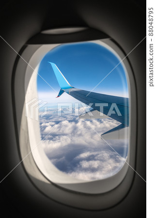 Airliner Flying Above the Clouds Seen Through the Porthole Airliner Flying Above the Clouds Seen Through the Porthole 88048795