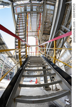 Bottom-up view of the metal staircase leading to the maintenance areas of the process equipment 88049050