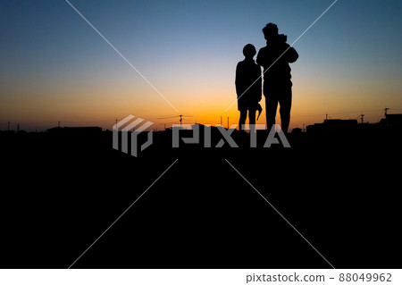 Parent-child silhouette against the backdrop of the setting sun Parent-child silhouette against the backdrop of the setting sun 88049962