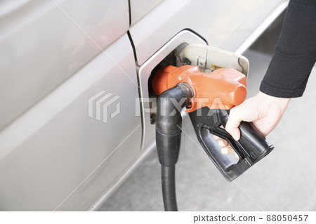 Hands of a woman refueling at a self-service gas station Hands of a woman refueling at a self-service gas station 88050457