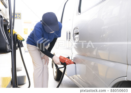 A woman refueling at a self-service gas station A woman refueling at a self-service gas station 88050603