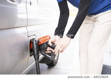 Hands of a woman refueling at a self-service gas station Hands of a woman refueling at a self-service gas station 88050604