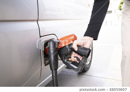 Hands of a woman refueling at a self-service gas station 88050607