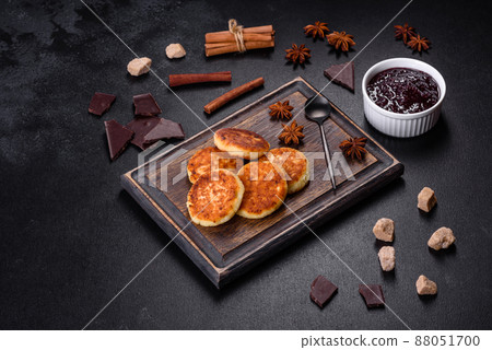Cottage cheese pancakes, syrniki, ricotta fritters on a wooden cutting board 88051700