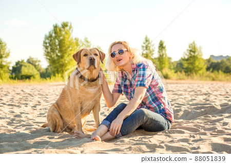 Young woman with her dog at the beach 88051839