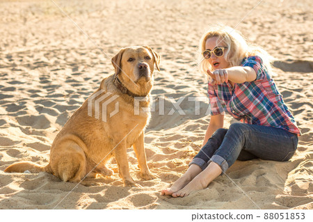 Young woman with her dog at the beach 88051853
