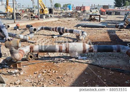 elements of the pipeline are at a construction site on the background of the process of Assembly of metal structures elements of the pipeline are at a construction site on the background of the process of Assembly of metal structures 88053531