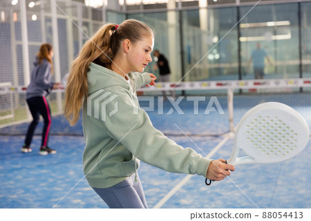 Girl tennis player playing padel tennis Girl tennis player playing padel tennis 88054413