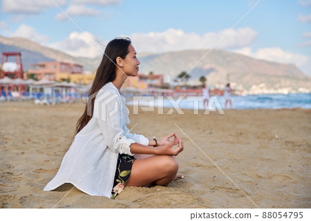 Young woman practicing yoga on the beach. 88054795