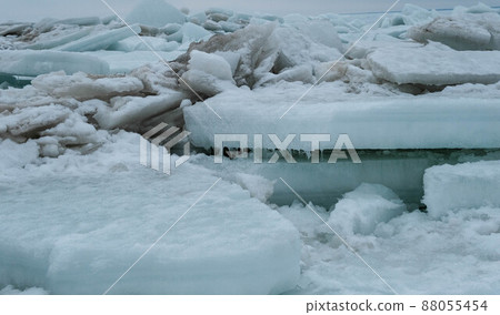 Frozen sea. Huge broken ice blocks stacked up on coast. Stormy weather in Parnu beach. Frozen sea. Huge broken ice blocks stacked up on coast. Stormy weather in Parnu beach. 88055454