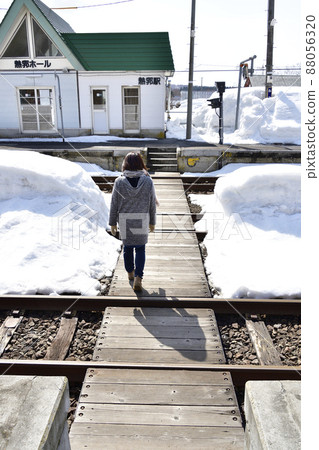 Taking a picture of a woman walking on the pedestrian crossing at Neppu Station in Kuromatsunai, Hokkaido in early spring Taking a picture of a woman walking on the pedestrian crossing at Neppu Station in Kuromatsunai, Hokkaido in early spring 88056320