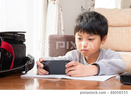 Elementary school boys looking at smartphones while studying Elementary school boys looking at smartphones while studying 88056555