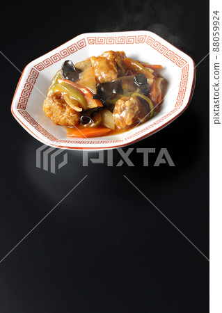 Photographed hot vinegared pork served on an octagonal Chinese plate on a black background Photographed hot vinegared pork served on an octagonal Chinese plate on a black background 88059924
