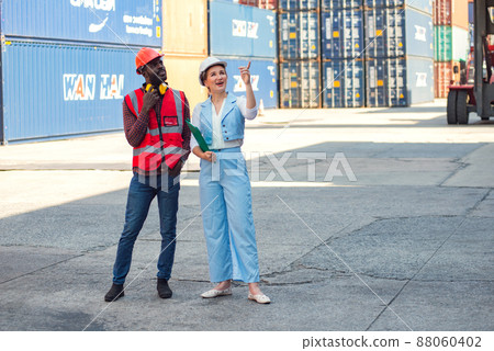 Businesswoman and engineer talking and checking loading Containers box from Cargo freight ship for import export. shipping in docks. 88060402