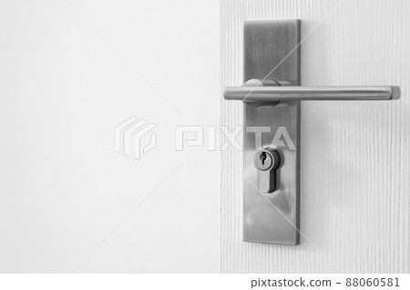 Modern door handle with keyhole on white door Modern door handle with keyhole on white door 88060581