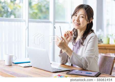 Business woman who operates a smartphone during desk work 88061454