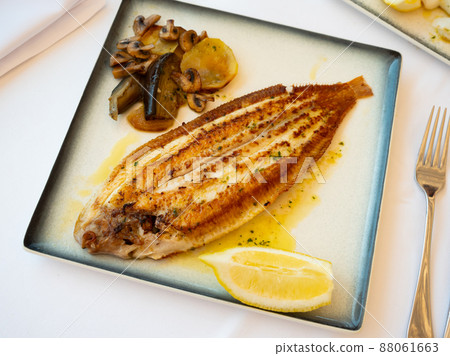 Roasted black sole fish with stewed vegetables and lemon Roasted black sole fish with stewed vegetables and lemon 88061663