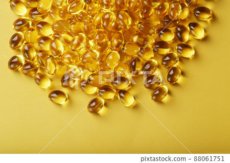 Pile of golden capsules of vitamin D3 on a yellow background with free space Pile of golden capsules of vitamin D3 on a yellow background with free space 88061751