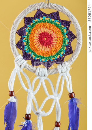 Amulet Dreamcatcher on a yellow background close-up protecting the sleeper Amulet Dreamcatcher on a yellow background close-up protecting the sleeper 88061764