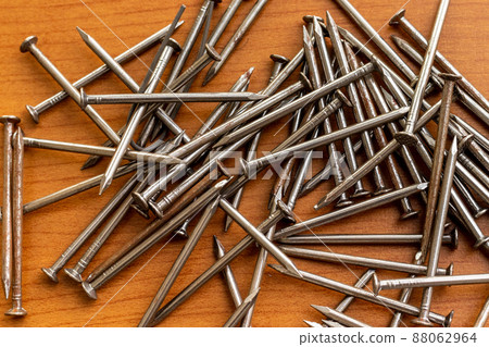 Nails scattered on a wooden board Nails scattered on a wooden board 88062964